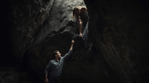 man-trying-pull-woman-down-from-higher-position.jpg