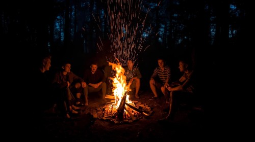 skupinka_muzov_sediacich_okolo_ohniska.jpg